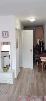 an empty living room with a door and a table at Jukan Apartman in Tuzla