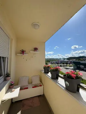 a balcony with two chairs and potted plants at Apartman Sanja in Doboj