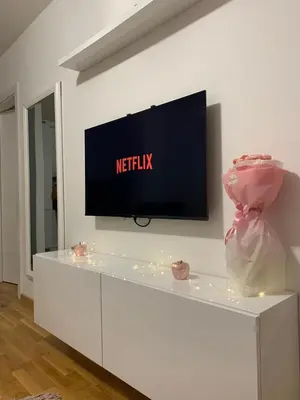 a living room with a tv on a white wall at Apartman Sanja in Doboj