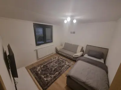 a living room with a couch and a tv at Apartman Veni in Zenica