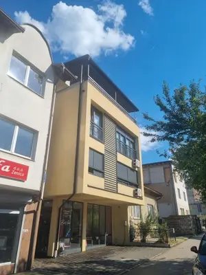 a building on a city street with a sky at Apartman Veni in Zenica