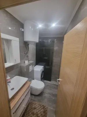 a bathroom with a white toilet and a sink at Apartman Veni in Zenica