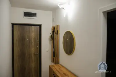 a hallway with a door and a mirror on a wall at Lux Apartment 1 - Zenica in Zenica