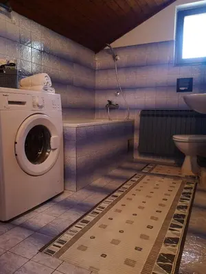 a washing machine in a bathroom with a toilet at Evergreen in Banja Luka