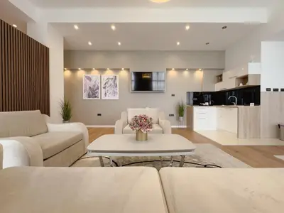a living room with white couches and a table at Hotel Via Vitez in Vitez