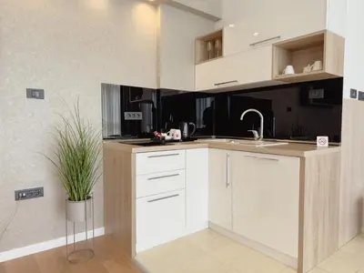 a kitchen with white cabinets and a potted plant at Hotel Via Vitez in Vitez