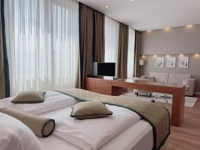 a bedroom with two beds and a desk and a couch at Hotel Via Vitez in Vitez