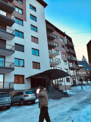 a person walking in front of a tall building at Apartment Vlasic in Šišava