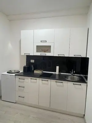 a kitchen with white cabinets and a sink at Apartman Mole in Livno