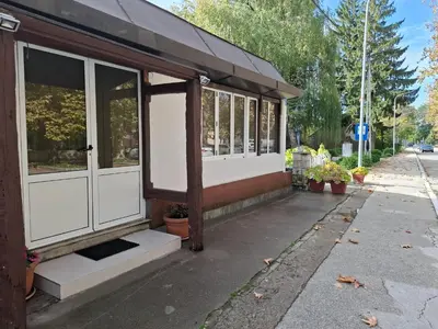 a building with white doors and windows on a street at Apartman Mole in Livno