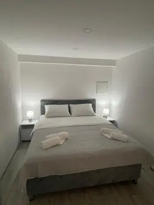 a bedroom with a large bed with two towels on it at Apartman Mole in Livno