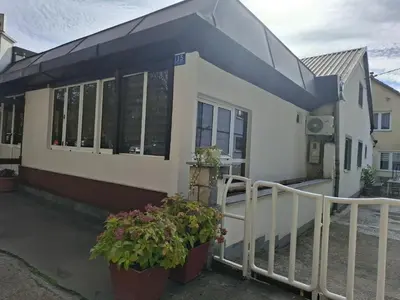 a house with two potted plants in front of it at Apartman Mole in Livno