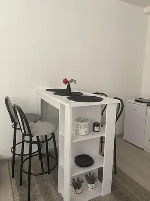 a white table with chairs and a table with a flower on it at Apartman Mole in Livno