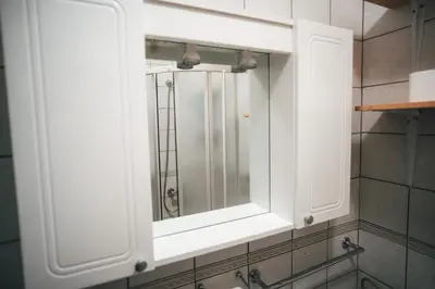 a white medicine cabinet in a bathroom with a mirror at Apartman Gnječ Kupres in Kupres