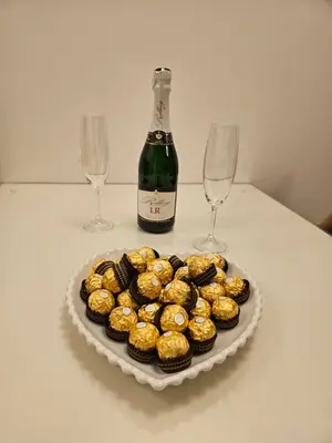 a plate of cupcakes and a bottle of wine and two wine glasses at Alex LUX Banjaluka in Železnička Stanica Incel