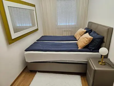 a bed with blue sheets and pillows in a bedroom at Alex LUX Banjaluka in Železnička Stanica Incel