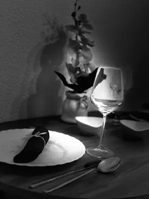 a table with a glass of wine and a plate at Apartman-Amko in Tuzla