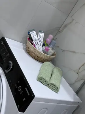 a washing machine with two towels and a basket on it at Apartman-Amko in Tuzla