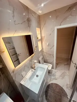 a bathroom with a sink and a mirror and a toilet at Apartman-Amko in Tuzla