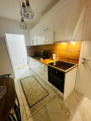a small kitchen with a stove and a refrigerator at Apartman-Amko in Tuzla