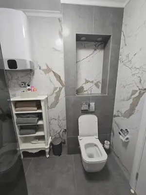 a bathroom with a white toilet and a sink at Apartman SANDRA in Modriča