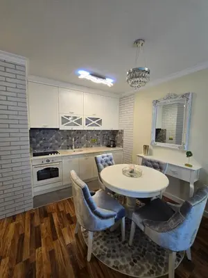 a kitchen with a table and chairs in a kitchen at Apartman SANDRA in Modriča