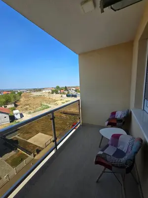 a balcony with a table and chairs and a large window at Apartman SANDRA in Modriča