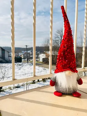 a teddy bear with a red hat sitting on a balcony at La Simba in Banja Luka