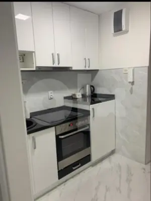 a kitchen with white cabinets and a stove top oven at Apartman 078 in Banja Luka