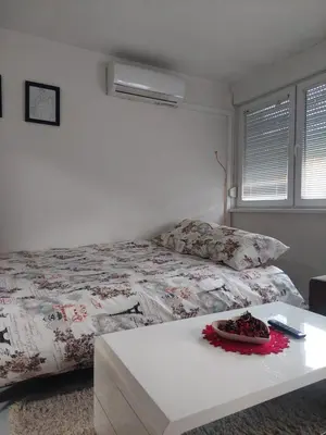 a bedroom with a bed and a white table at Apartman 078 in Banja Luka