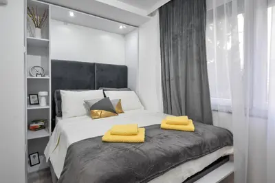 a bedroom with a bed with yellow towels on it at Apartman LILI centar in Banja Luka