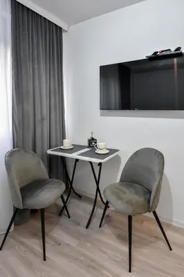 a table and two chairs in a room with a tv at Apartman LILI centar in Banja Luka