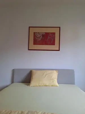 a bed with a pillow and a picture above it at Apartmani Sweet Dreams in Banja Luka