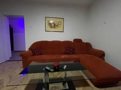 a living room with a brown couch and a glass table at Apartmani Sweet Dreams in Banja Luka