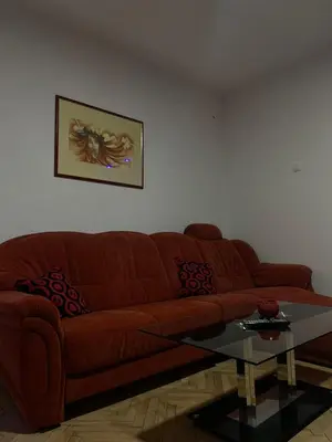 a living room with a brown couch and a glass table at Apartmani Sweet Dreams in Banja Luka