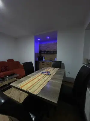 a large wooden table in a room with chairs at Apartmani Sweet Dreams in Banja Luka