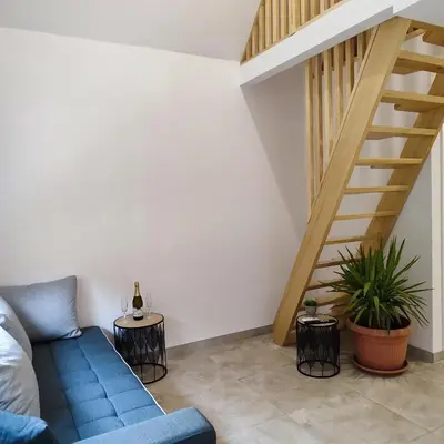 a living room with a blue couch and stairs at Vikendica La Anja in Laktaši