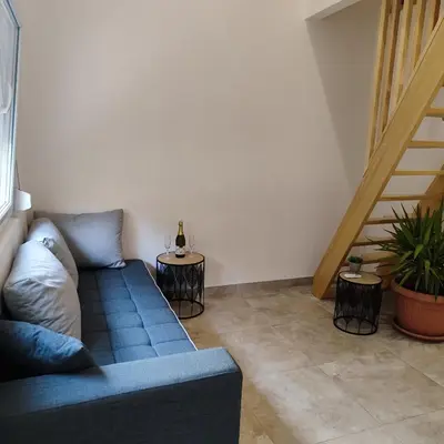 a living room with a blue couch and two tables at Vikendica La Anja in Laktaši