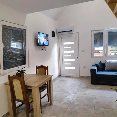 a living room with a table and a couch at Vikendica La Anja in Laktaši