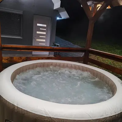 a hot tub in a backyard at night at Vikendica La Anja in Laktaši
