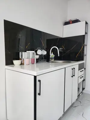 a white kitchen with a sink and a counter at Apartmani City ES in Cazin