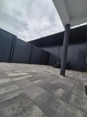 a patio with a black wall and a pole at Apartmani City ES in Cazin
