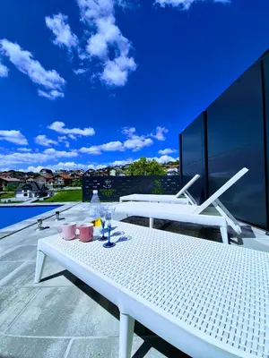 a white table and chairs on a balcony at Apartmani City ES in Cazin