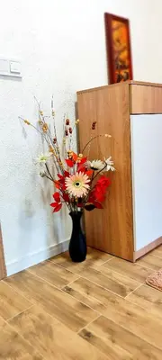 a vase with flowers in it next to a wall at Apartman Duric in Tuzla