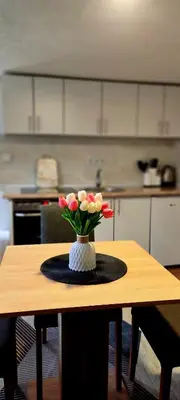 a vase of flowers on a table in a kitchen at Apartman Duric in Tuzla