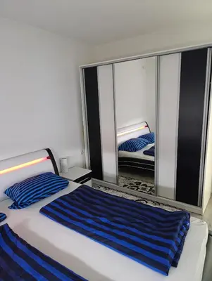 a bedroom with a bed and a large mirror at Apartman Ella in Bosanska Krupa