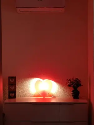 a heart light in a room with a red wall at Apartman Ella in Bosanska Krupa