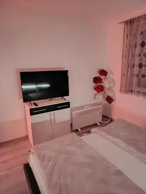 a bedroom with a flat screen tv on the wall at Apartman Ella in Bosanska Krupa