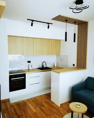a kitchen with white cabinets and a blue couch at Apartment Shine - Borik in Banja Luka