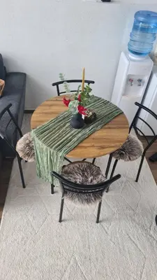a dining room table with a cat sitting around it at Lukina koliba-vikendica-Manjaca in Banja Luka